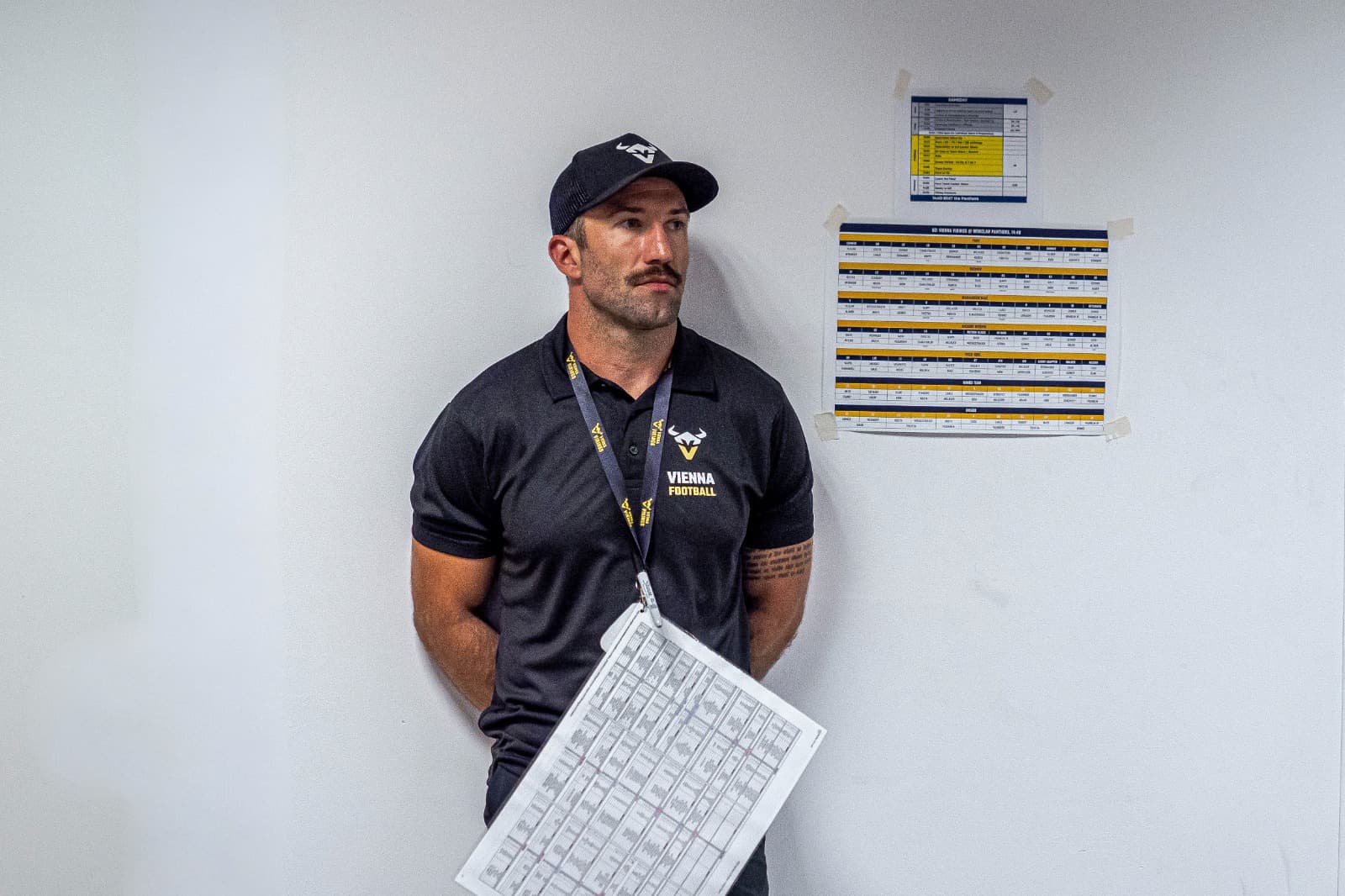 Michael Gentilli against a wall of taped-up game-day call sheets, holding his own