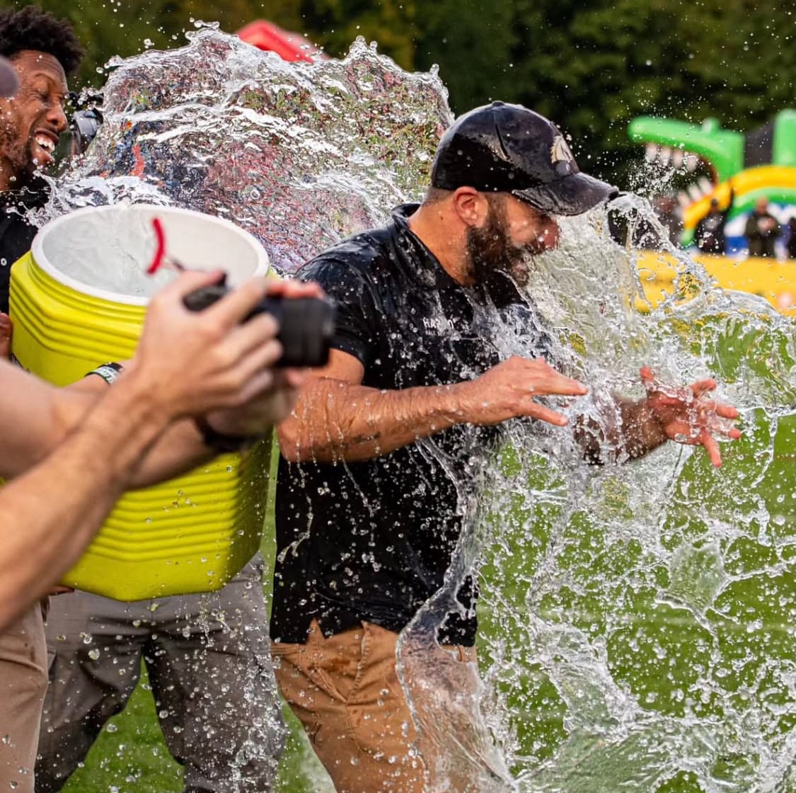 Michael Gentilli taking a cooler of water over the head after the final whistle